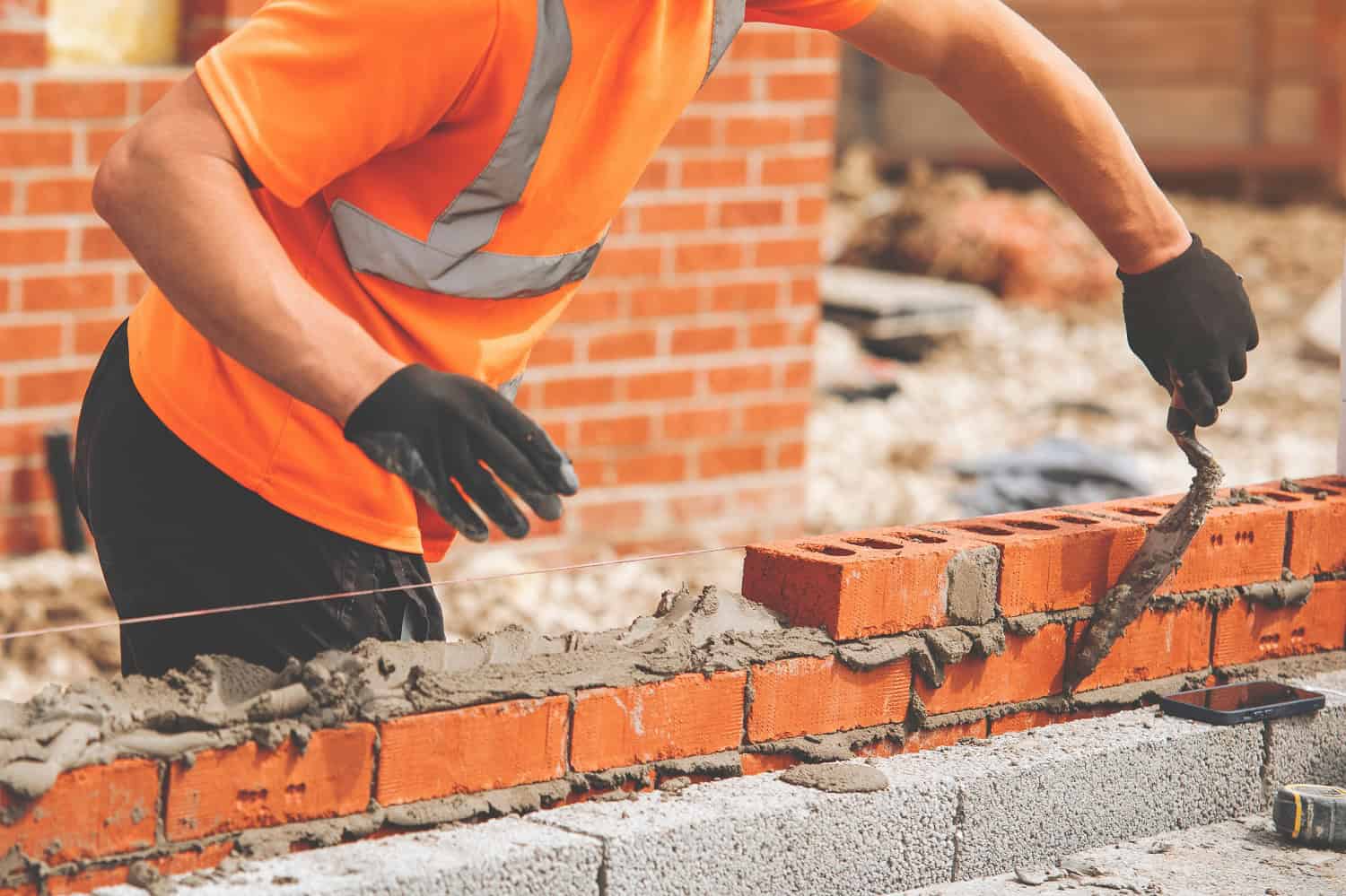 Bricklayers,With,Masonry,Trowel,Laying,Bricks,On,Mortar,At,Building