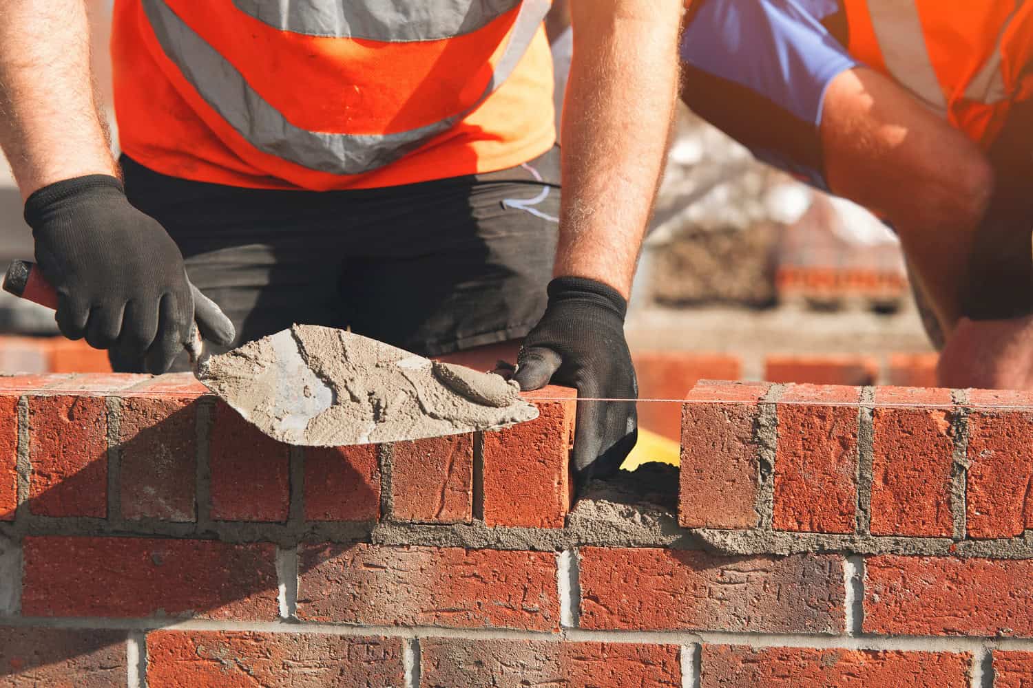 Construction,Workers,Laying,Bricks,At,A,Building,Site,During,Daylight,